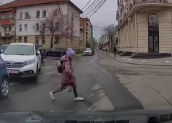 O elevă, la un pas să ajungă sub roţi: Momentul în care copila trece strada, în loc nepermis, răsărind de după mașini parcate