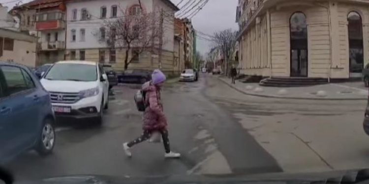 O elevă, la un pas să ajungă sub roţi: Momentul în care copila trece strada, în loc nepermis, răsărind de după mașini parcate