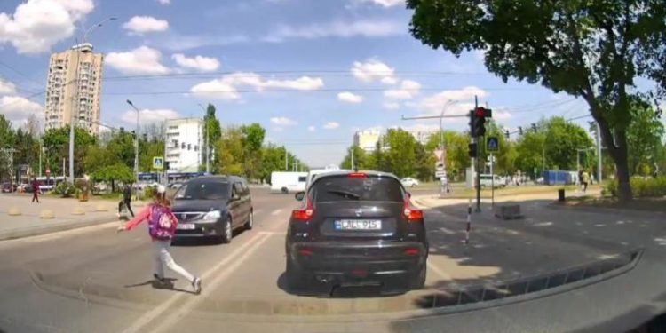 Imagini ce îţi taie respiraţia: Momentul în care o fetiță sare chiar în fața maşinilor şi traversează strada | FOTO
